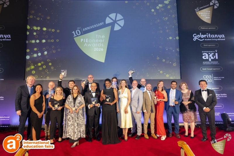 SEED colleagues on stage at the PIEoneer Awards, holding trophies in front of a lit backdrop